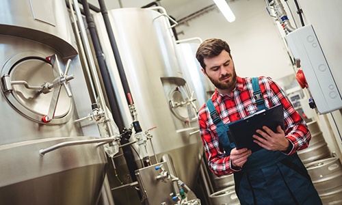 Manufacturer-reading-export-support-notes-about-product-changes-to-his-drinks-product.jpg