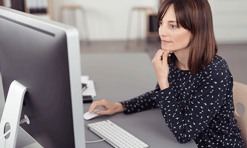 Woman-sitting-at-her-desk-using-her-computer-to-collect-and-store-customer-data.png